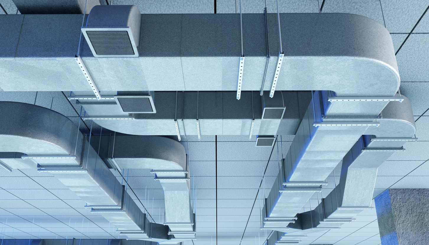 Intérieur technique montrant un système de plomberie complexe avec tuyauterie en cuivre et robinetterie